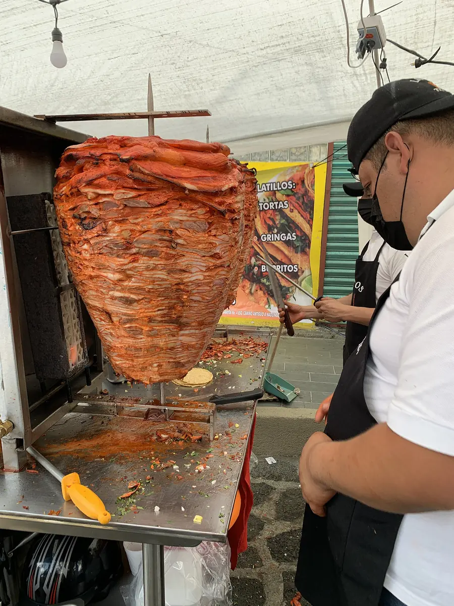 Trompo de pastor girando con la carne marinada dorada
